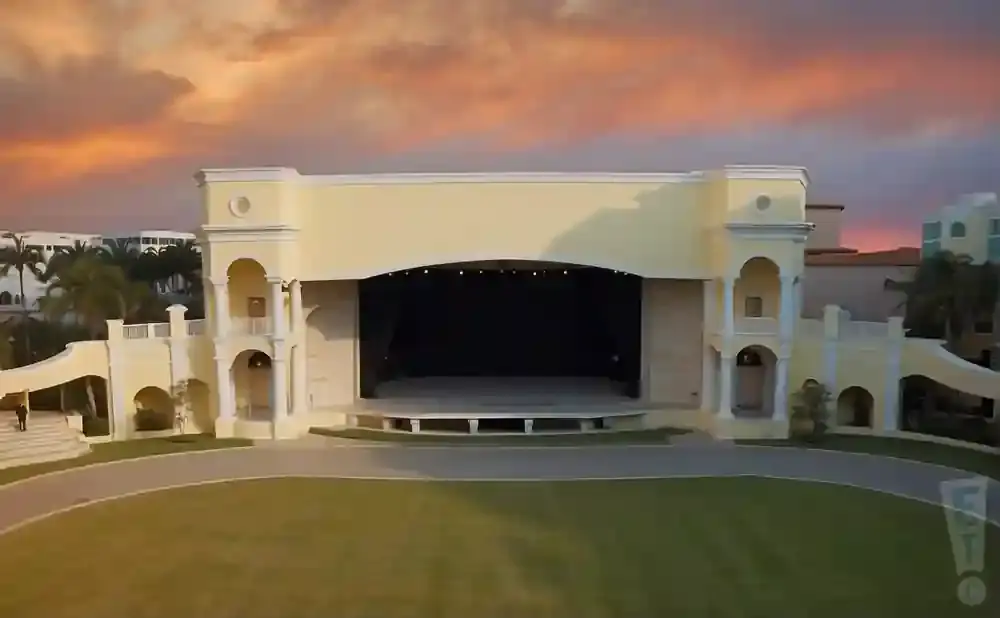 Outdoor amphitheater with a stage and seating area at sunset.