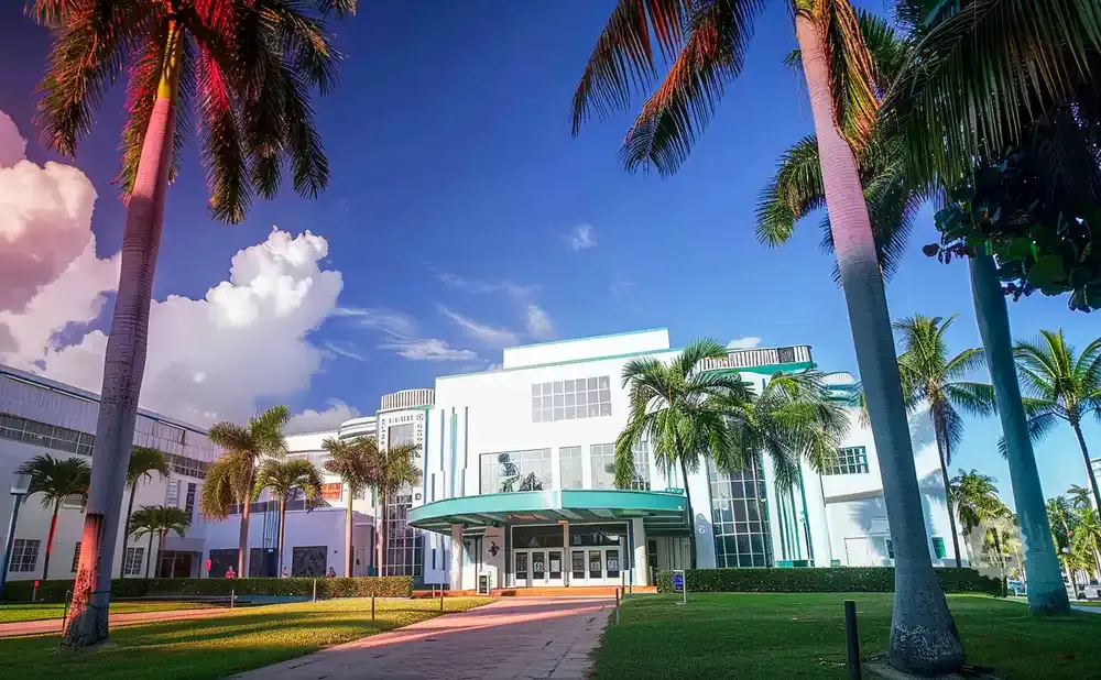 Art Deco building with palm trees and a bright blue sky.