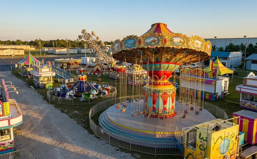 An aerial view of a carnival with rides, games, and food stands set up.
