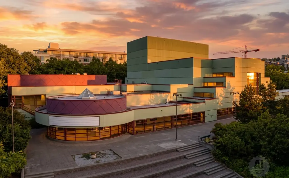 Modern building with a circular entrance under a sunset sky.