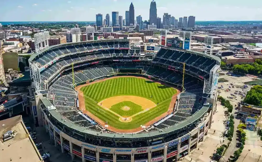 Aerial view of a baseball stadium with a city skyline in the background.