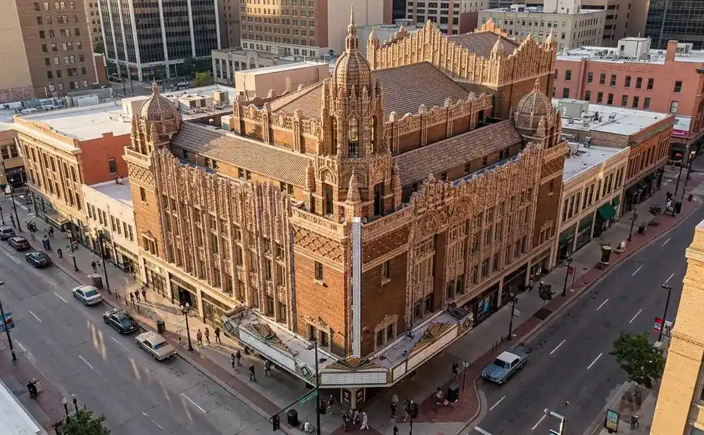 Aerial view of an ornate, historic brick theatre with detailed architectural carvings, set within a city block.