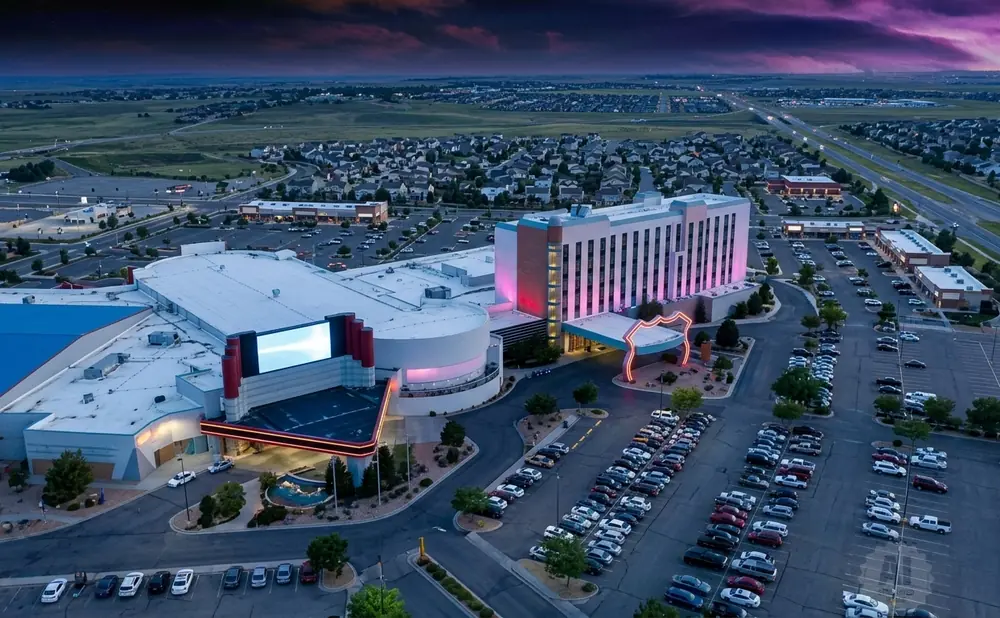 Aerial view of a casino and hotel complex at dusk with a purple sky.