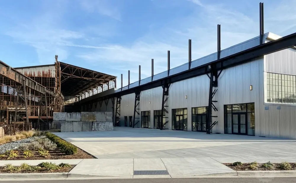 Industrial building with a modern metal addition next to a rusted structure.