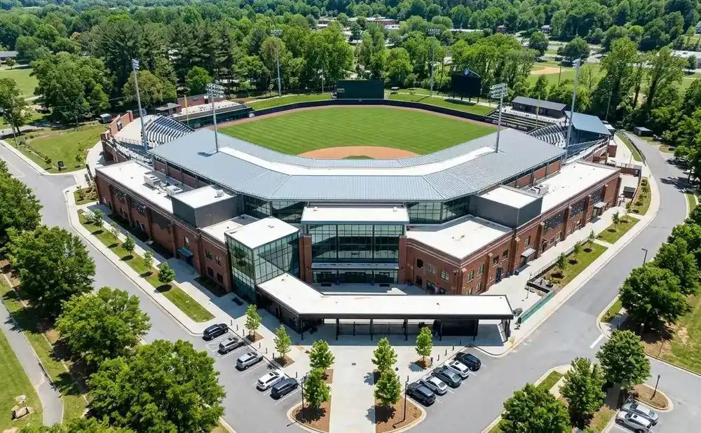 Aerial view of a baseball stadium with brick buildings and a green field.