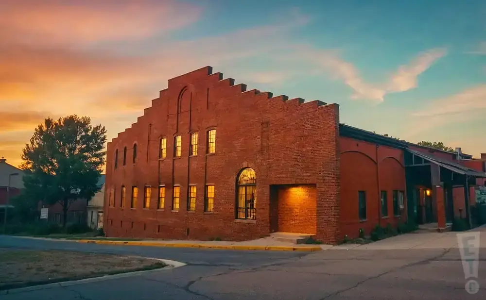 Red brick building with large windows at sunset.