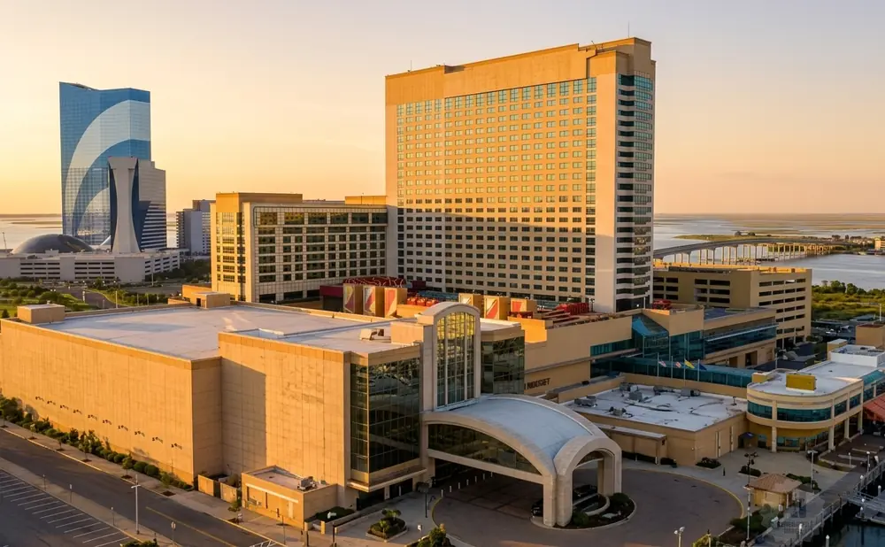 Resorts Casino Hotel in Atlantic City, NJ, bathed in golden hour light, with a tall blue skyscraper and casino complex.