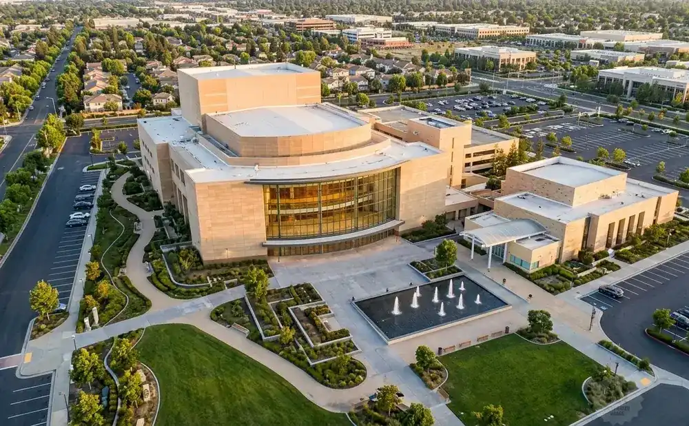 Aerial view of a modern building complex with fountains and landscaped gardens.