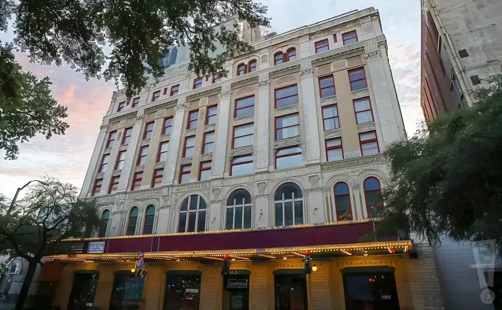 A vintage building with a marquee and ornate facade, seen from a low angle.