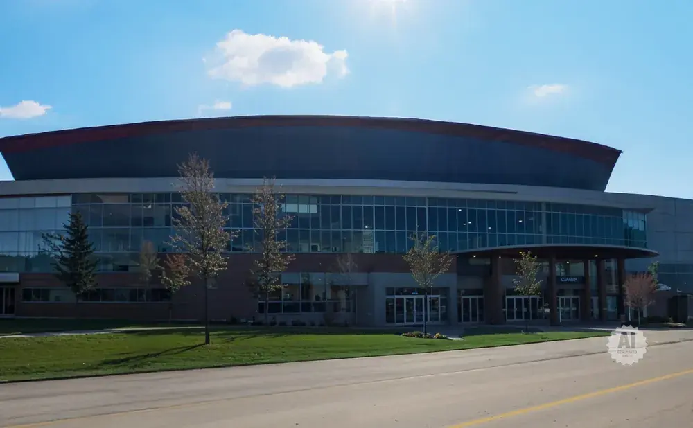 Exterior view of a modern convention center with a large arched roof and glass facade.