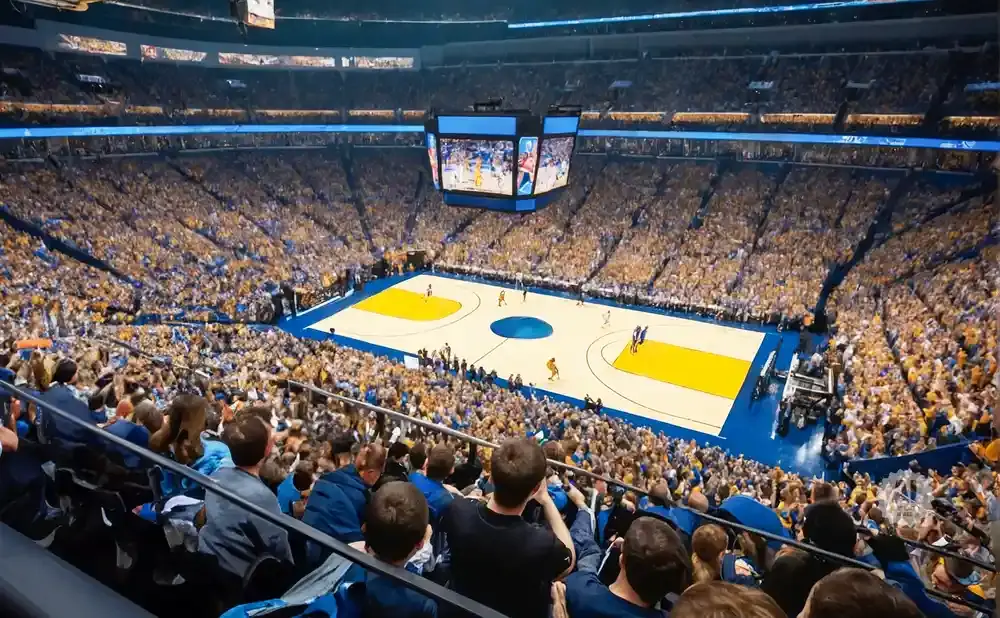 Basketball game in a crowded stadium with fans in gold and blue.