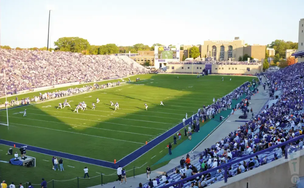 A football game is being played in a stadium with a large crowd in the stands.