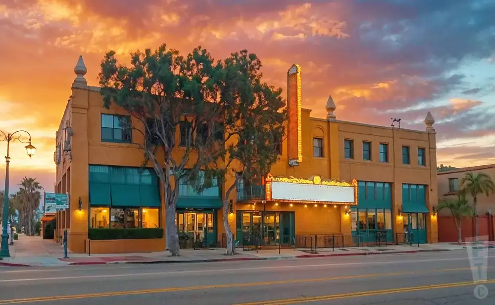 Orange theater building with marquee at sunset.