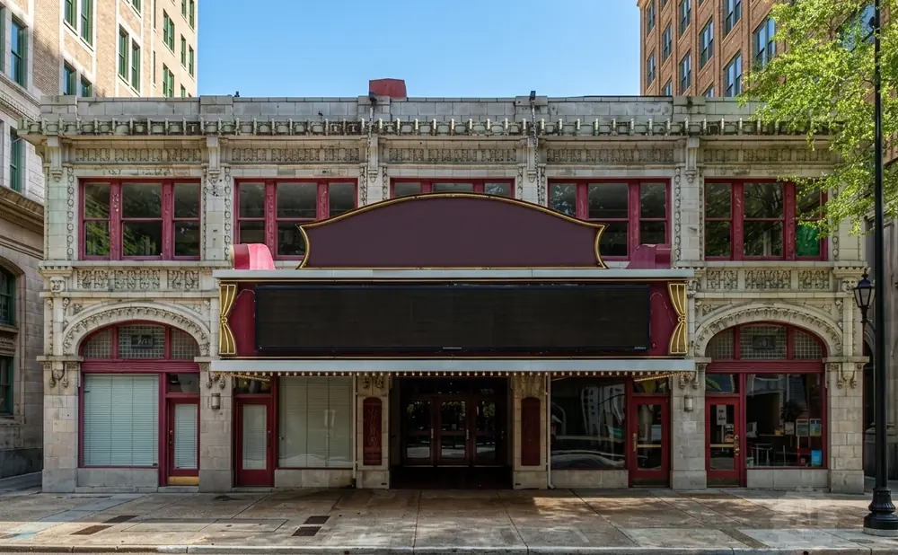 Exterior of a vintage movie theater with a marquis and ornate stonework.