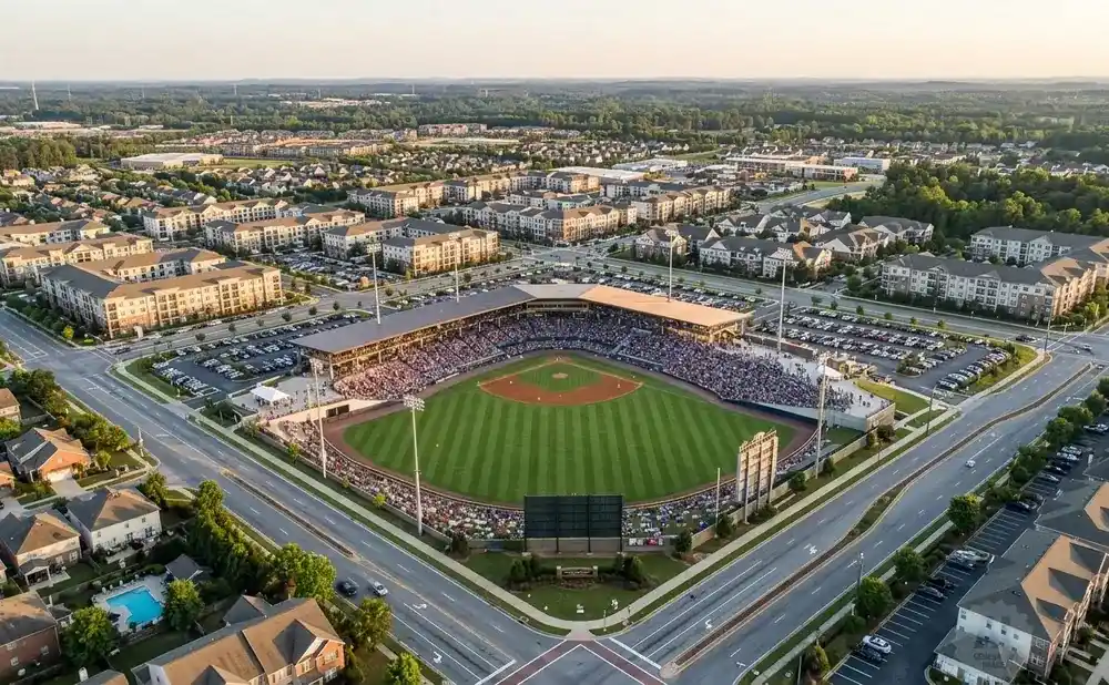 Aerial view of a baseball stadium filled with fans, surrounded by residential buildings and parking lots.