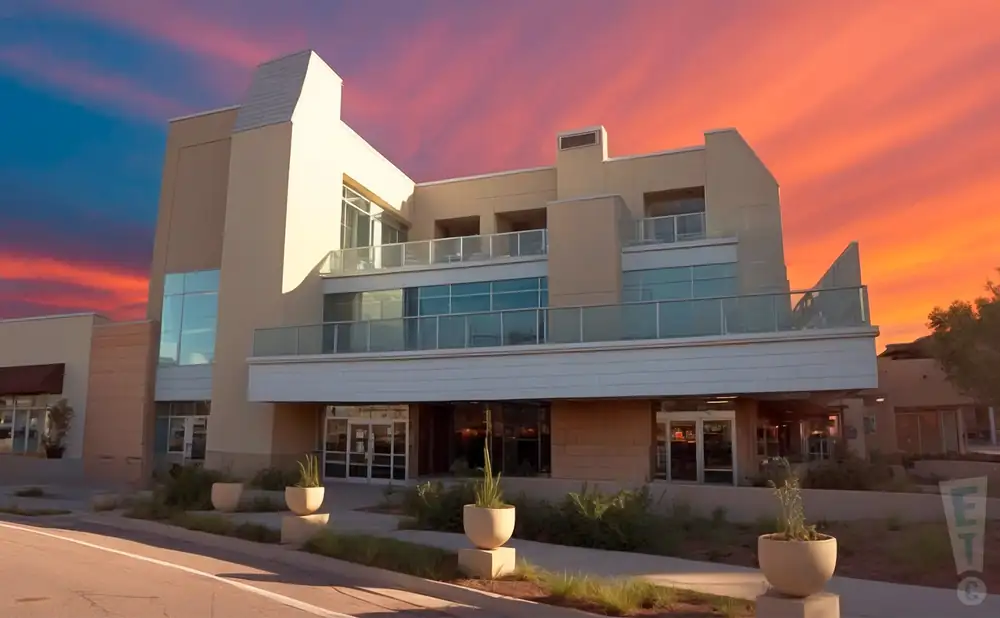 a promotional exterior picture of comedy works south in greenwood village, colorado, captured during golden hour with a vivid orange and pink sky.
