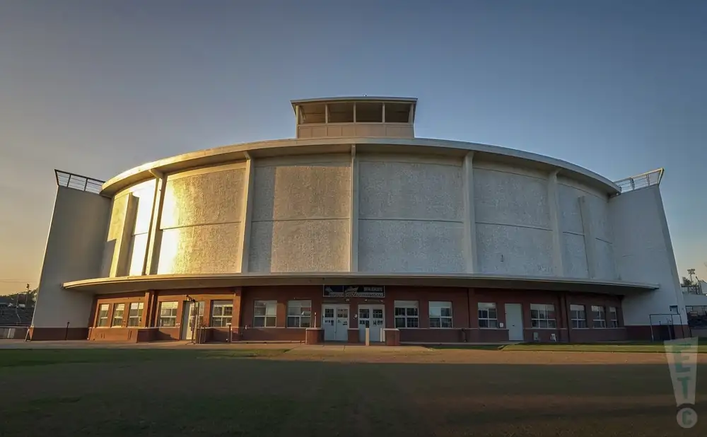 a hyper-realistic photograph of venue, nat bailey stadium in vancouver, british columbia, captured at sunset with golden light accentuating the classic baseball park design.