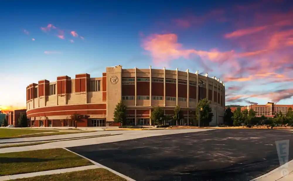 exterior promotional venue picture of west virginia university coliseum with a sunset sky.