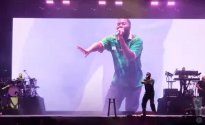 Singer on stage with large screen displaying a projection of him.