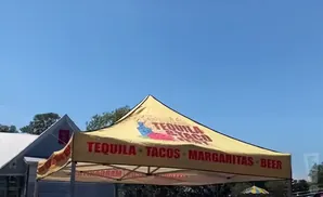A yellow tent at an outdoor event advertises 