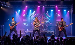 A rock band performs on a stage lit by purple and blue lights, with the singer center stage.