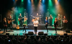 Irish dancers and musicians perform on a stage with colorful lights and smoke.