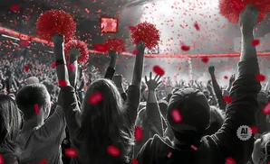 Crowd cheering with red pom-poms and confetti, in grayscale with red accents.