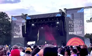 Austin City Limits Music Fest stage with large banners and a crowd of concertgoers.