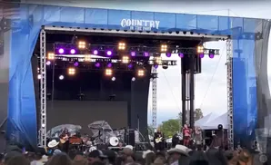 A band performs on an outdoor stage with 