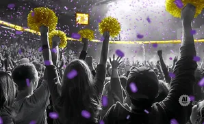 A crowd cheers at a concert or sporting event, with gold pom-poms and purple confetti.