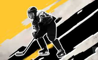 A hockey player in uniform skates with a stick.