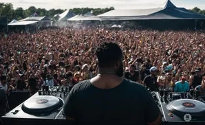 DJ at a lively outdoor music festival, with a large crowd cheering and hands in the air.