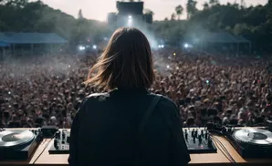 DJ playing music to a large crowd at an outdoor festival.