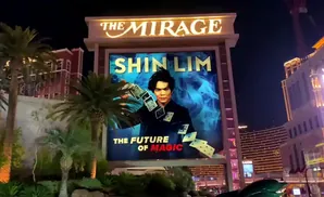 A billboard for Shin Lim's magic show at The Mirage, featuring his portrait and playing cards.