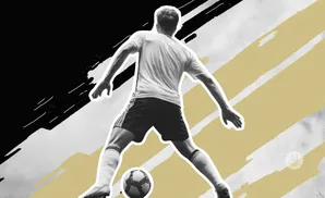 A soccer player in mid-stride with a ball at his feet.