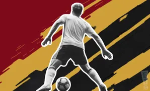 A soccer player in black and white from behind, dribbling a ball, with a red, gold, and black background.