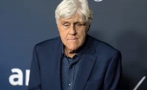 Jay Leno in a dark blue suit and patterned shirt.