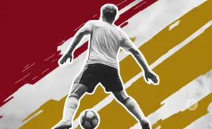 Soccer player with ball in black and white against a red and gold abstract background.