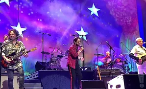 ringo star peforming on stage holding a microphone