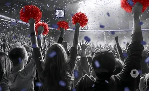 Crowd cheering with red pom-poms and blue confetti.