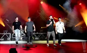 98 degrees peforming on stage in front of red light