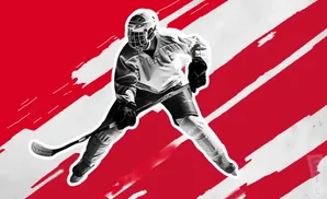 Hockey player in full gear with stick, against a red and white striped background.