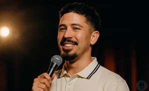A man holds a microphone and smiles.