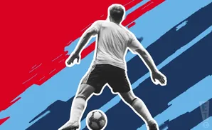 Soccer player in black shorts and white jersey, mid-action, with a ball at his feet against a red and blue abstract background.