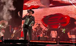 eden munoz performing on stage with a band under multicolored lights