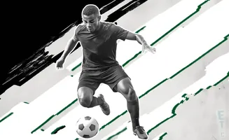 A black and white photo of a soccer player dribbling a ball, with green and white abstract streaks in the background.