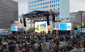 A large outdoor concert stage with screens displaying 