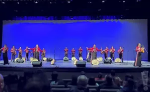 Mariachi band performing on a stage with a blue backdrop.