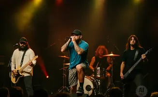 A band performs on stage with a lead singer, guitarist, and bassist.