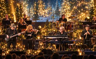 A band performs holiday music on a stage decorated with Christmas trees and lights.